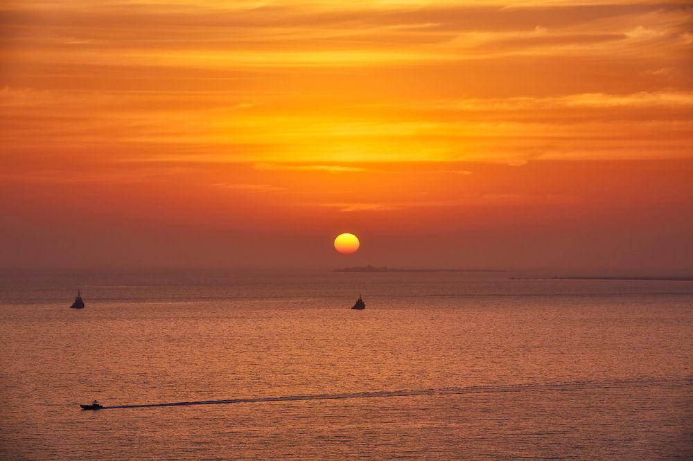 Four Seasons Hotel Doha Exterior photo Sunset over the Gulf of Naples